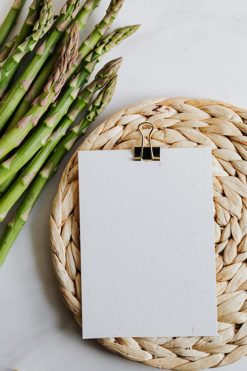 asparagus and blank paper on table