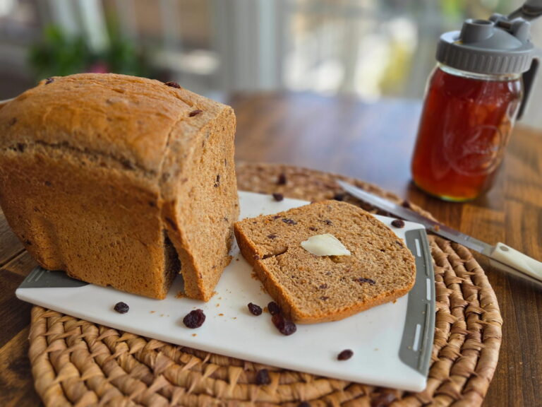 Cinnamon Raisin Bread with melted butter and raisins sprinkled around it.