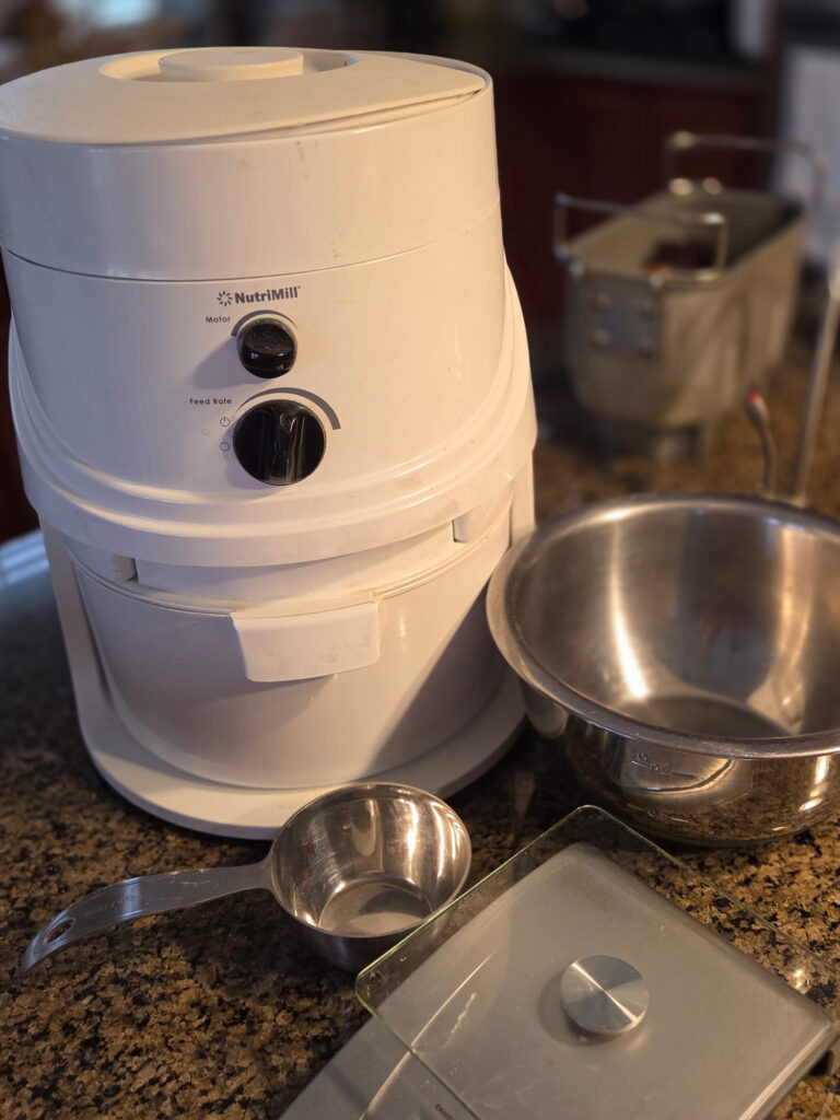 Kitchen equipment including grain mill, scale, bowl and measuring cup