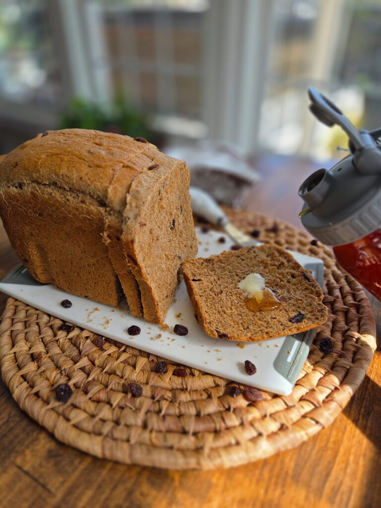 Freshly milled flour cinnamon raisin bread sliced with butter and honey pouring