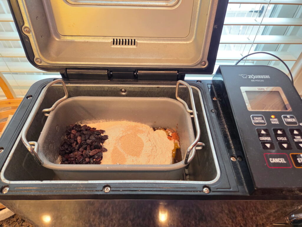 Ingredients for cinnamon raisin bread in bread machine pan inside bread machine prior to cooking